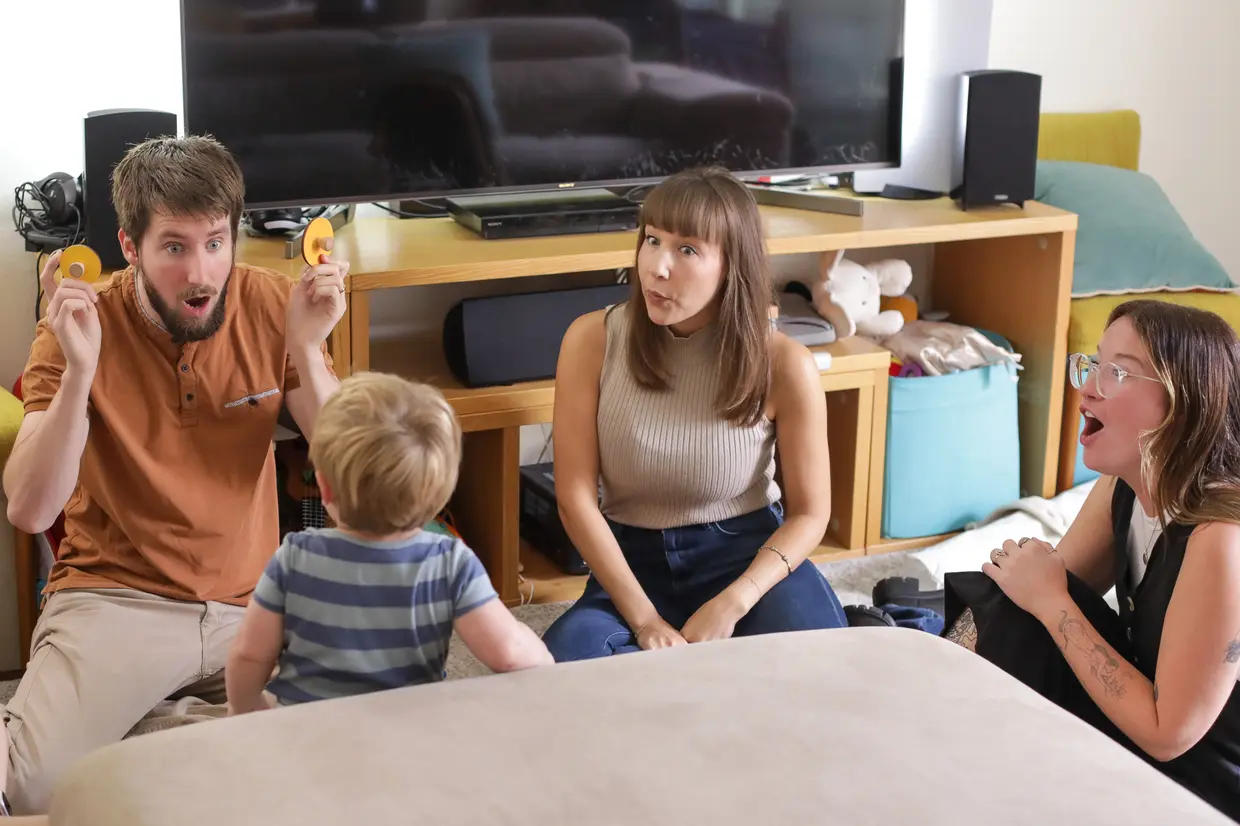 Three speech therapists engaging a toddler in a play-based therapy session